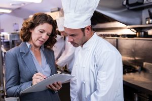 QC at restaurant kitchen standing with chef - Value of Sanitation Certification of Food Equipment | NSF